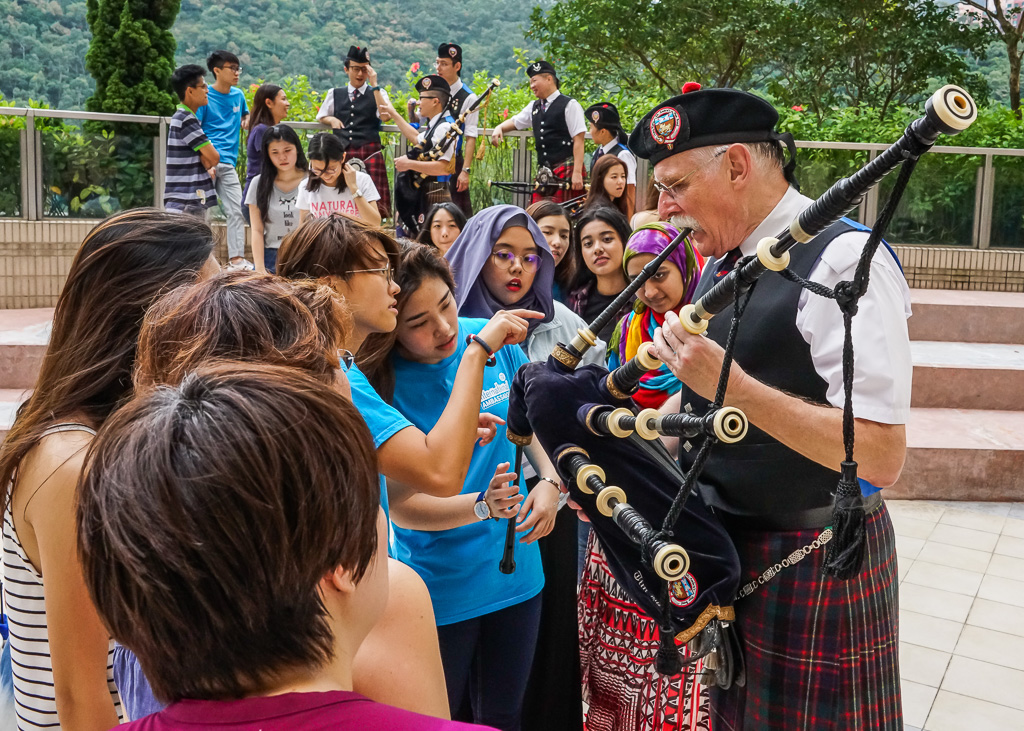 Curious exchange students and International Ambassadors inquire about the bagpipe’s mechanics.