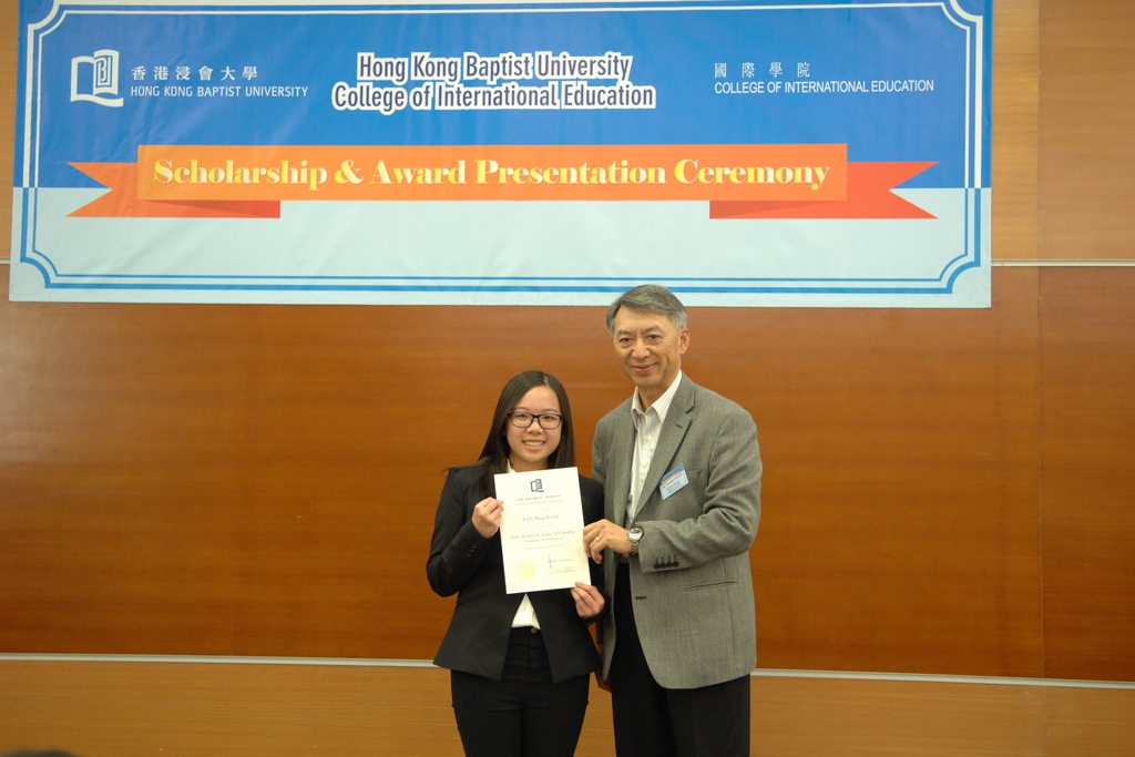 同学接受香港浸会大学国际学院咨询委员会主席<br/>杨浩明先生（右）颁发奖学金证书。