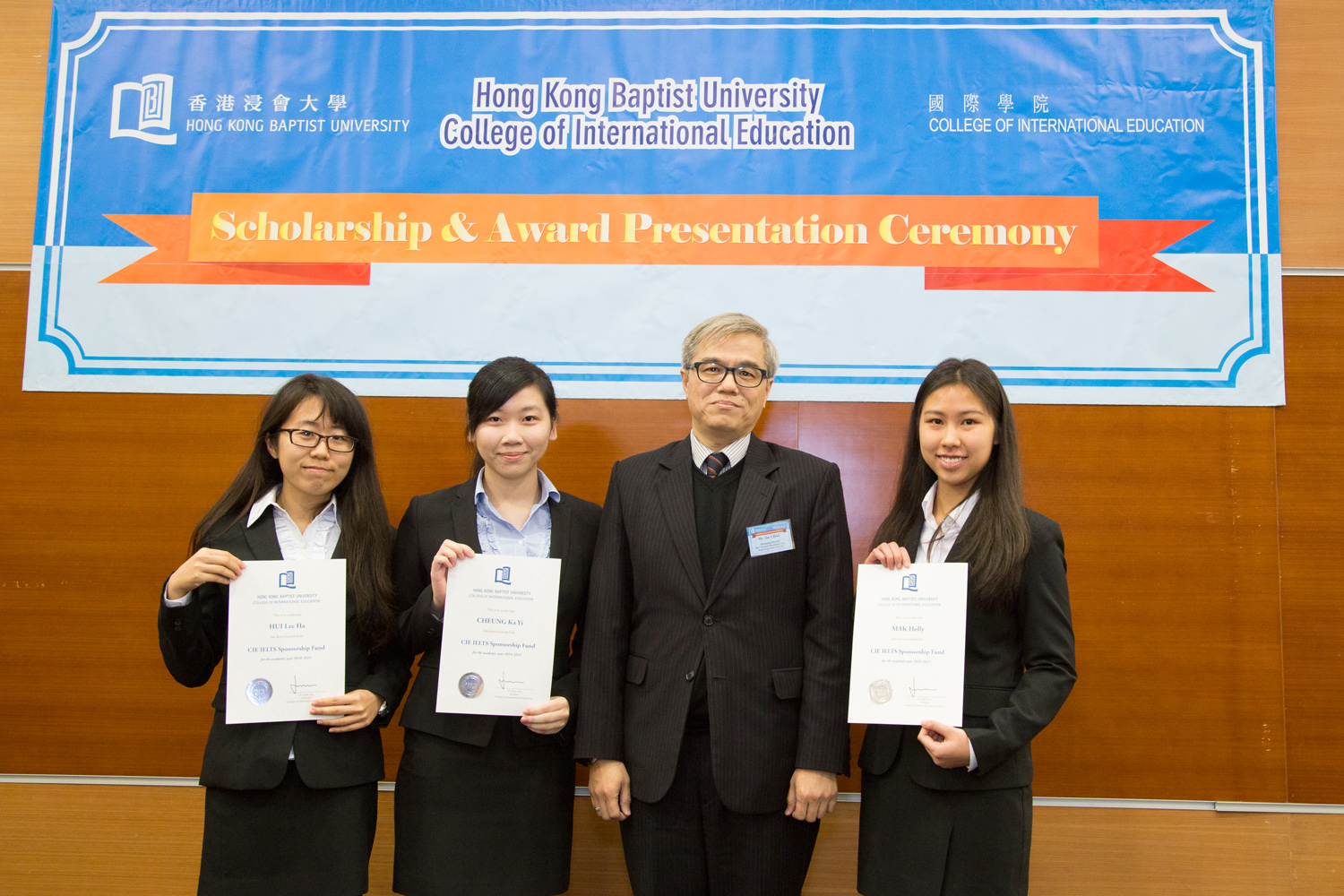 同學接受浸大國際學院諮詢委員會委員巢國明先生（中）頒發獎學金證書。