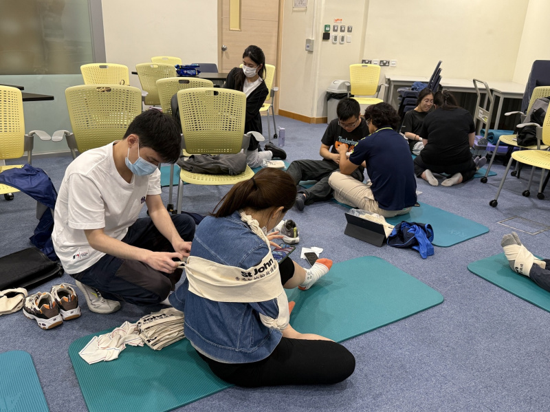 同学互相进行包扎练习。
