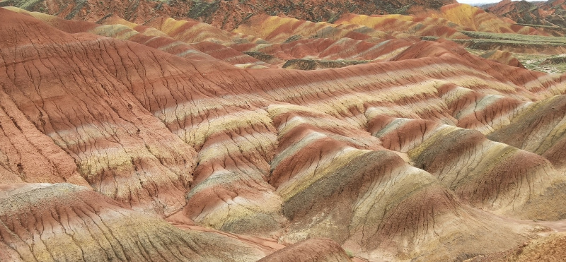 张掖联合国教科文组织世界地质公园位于中国甘肃省，以其壮观的彩色山脉而闻名，这些山脉由红色、黄色、蓝色、白色和绿色混合的砂岩组成。 [照片来源：蔡慕贞女士]
